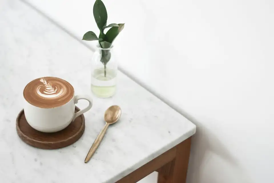 Taza de café con leche sobre una barra de mármol