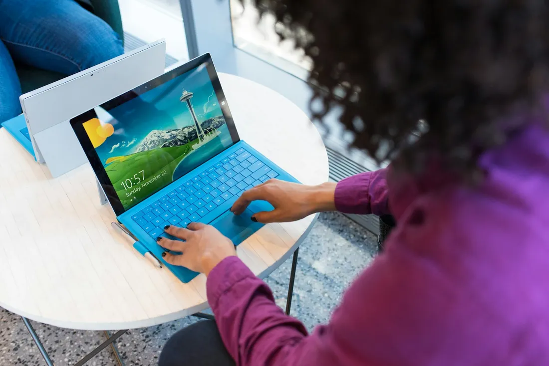 A person types on a laptop by a window: the page is built in HTML, not in a visual editor